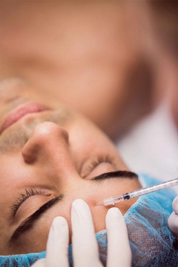 A forehead injection being given during a facial aesthetic treatment